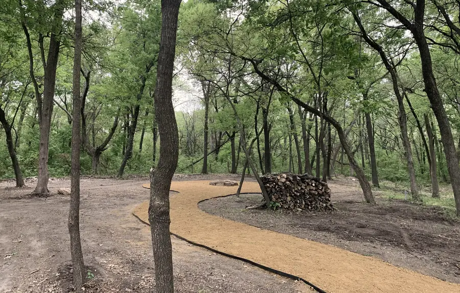 Gravel walking trail curving through the woods at Sundowner RV Park